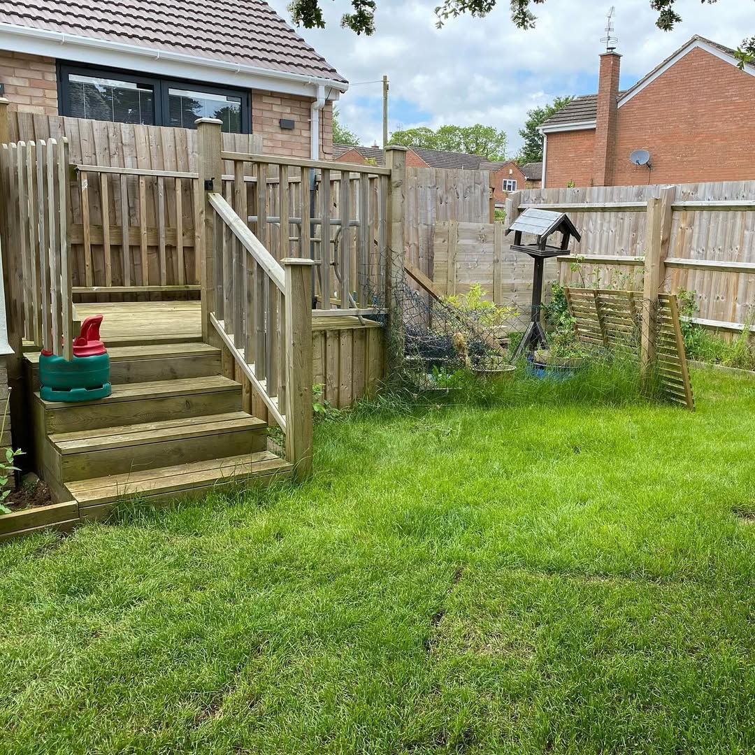 Old raised decking, scruffy lawn and weathered fencing before the rebuild