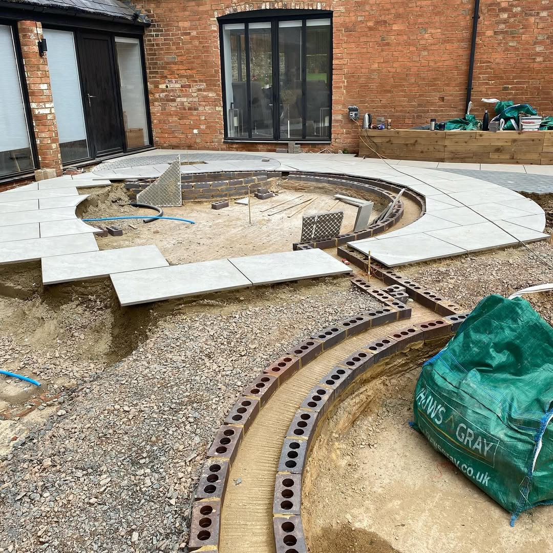 Curved porcelain patio being laid around the brick-built rill