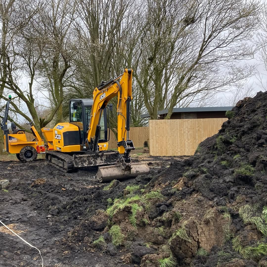 Mudworks team on site with a JCB excavator preparing ground for a garden build