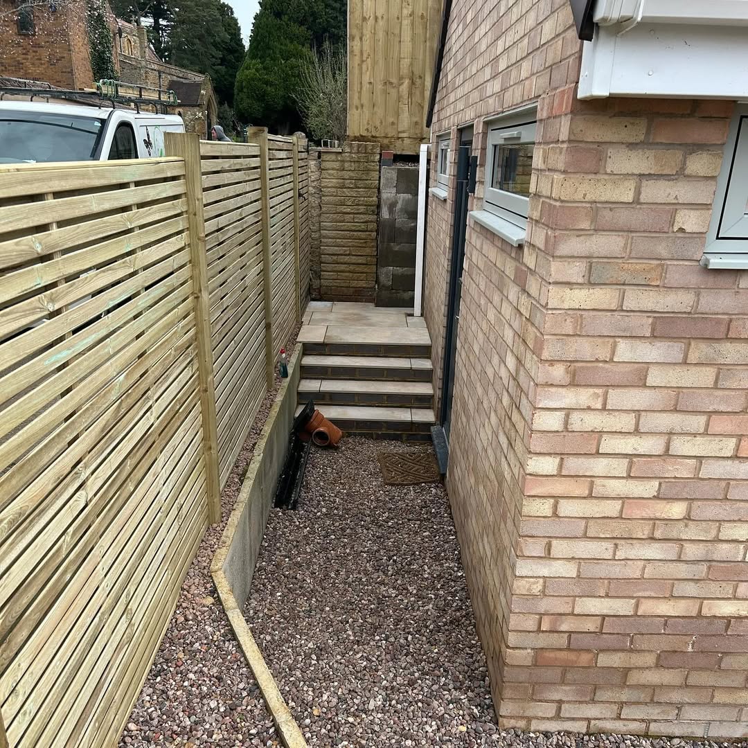 New slatted-top fence panels and tiled steps closing off the side passage