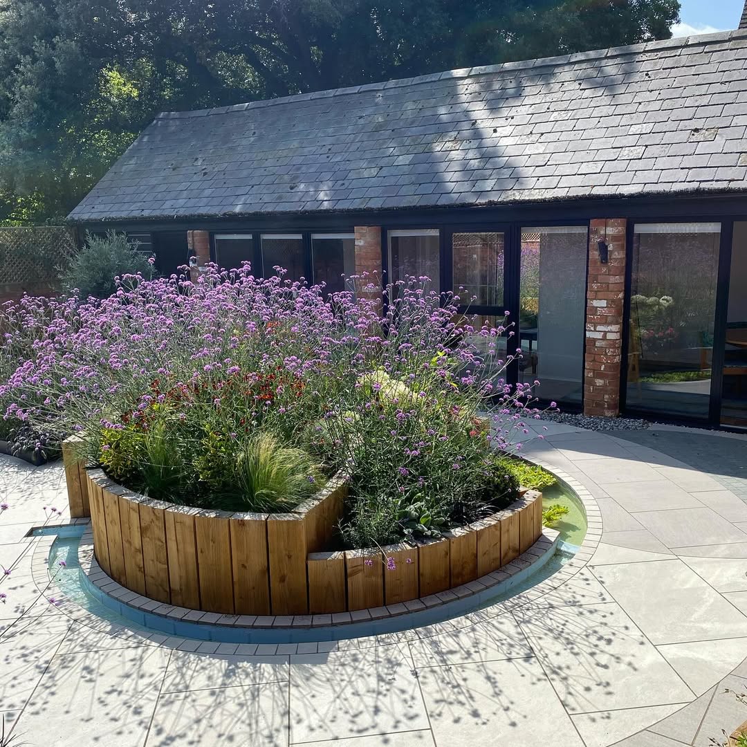 Tiered sleeper planter in full bloom against the bifold doors